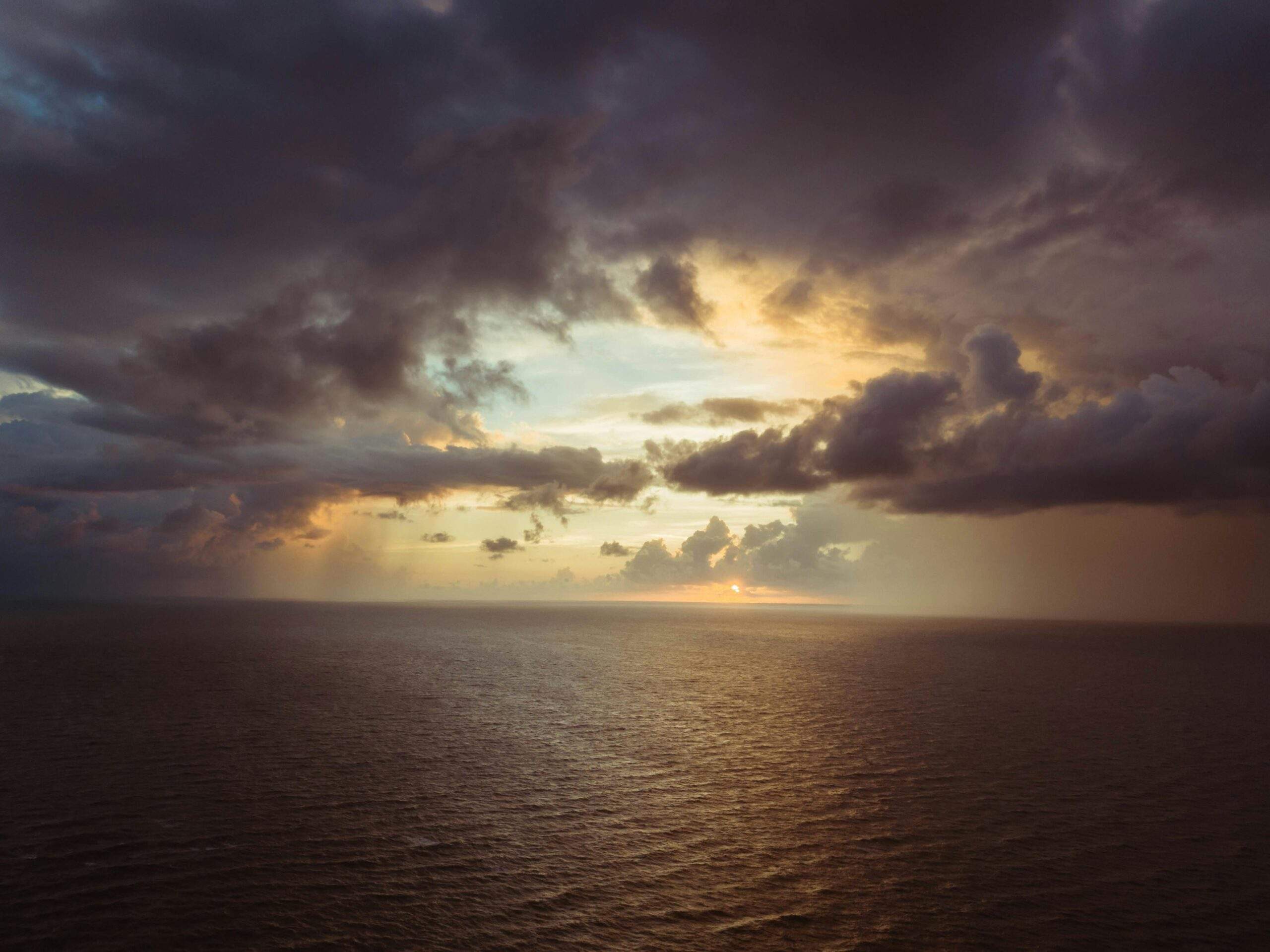 Person turning dark clouds into bright light, symbolizing positive belief transformation.