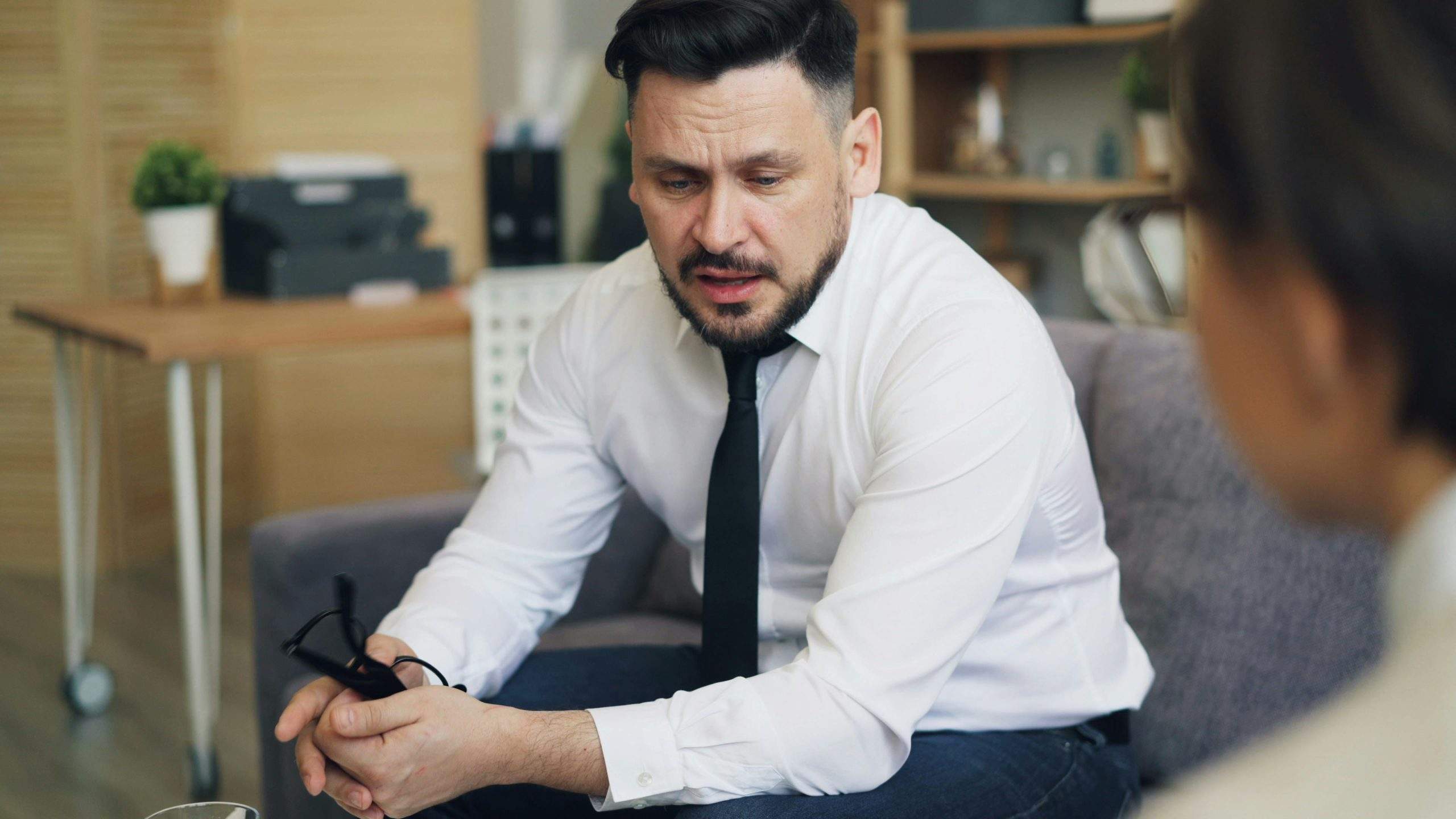 Stressed professional at desk overwhelmed by work, highlighting depression’s impact on career and earnings.