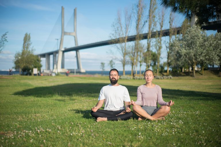 Person meditating outdoors to manage stress and build emotional resilience.