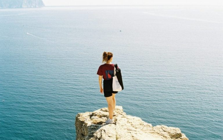 A person standing on a cliff reflecting on failure and personal growth.