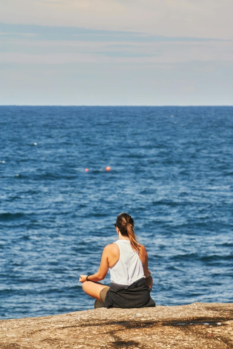 A person meditating outdoors, reflecting mindfulness and emotional resilience.