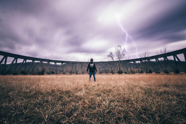 A person standing strong against a storm, representing resilience and perseverance.