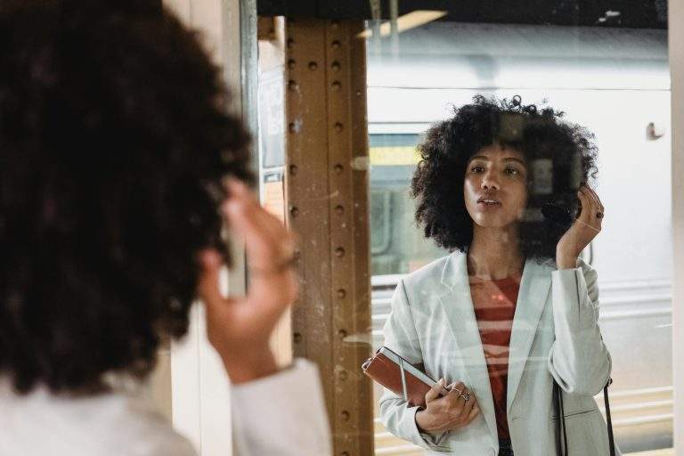 Person reflecting in a mirror with text highlighting five common self-reflection mistakes and how to avoid them for personal growth.