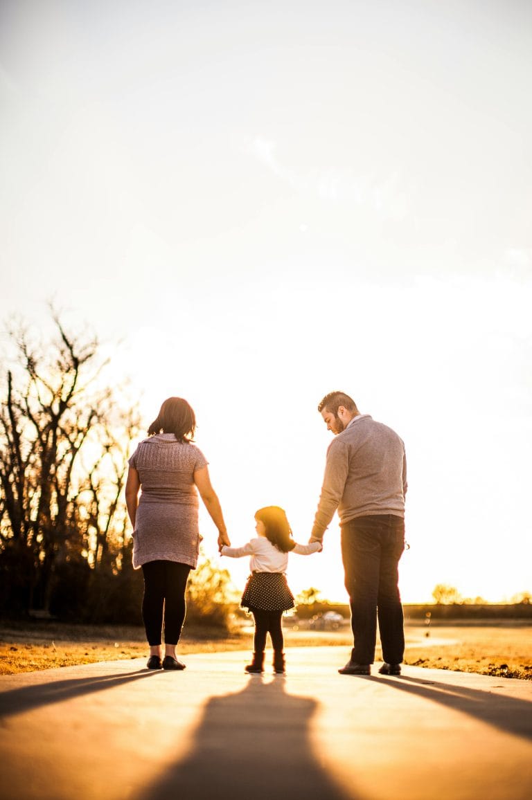 Photo of family standing outdoors during golden hour