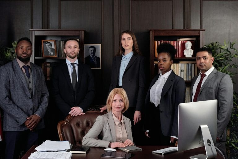 A team of professionals collaborating at a table, showcasing the democratic leadership style in action.