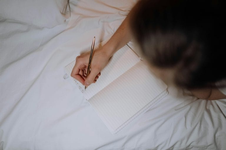 Person reflecting and journaling daily questions for personal growth