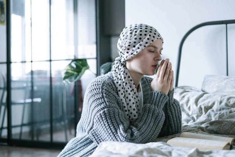 Person praying in a peaceful setting, symbolizing hope and healing from depression through prayer.