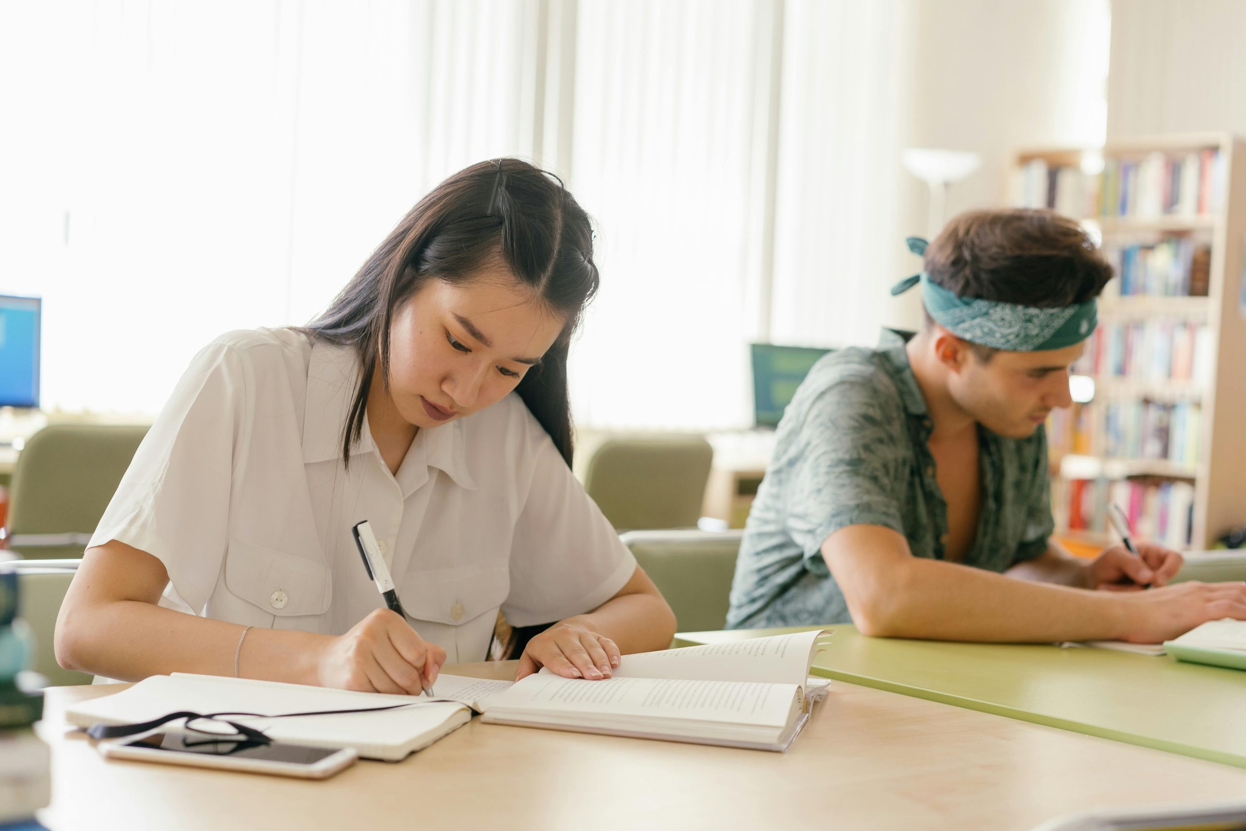 A student praying at a desk with books and a calm expression, reflecting faith and determination during exam preparation.